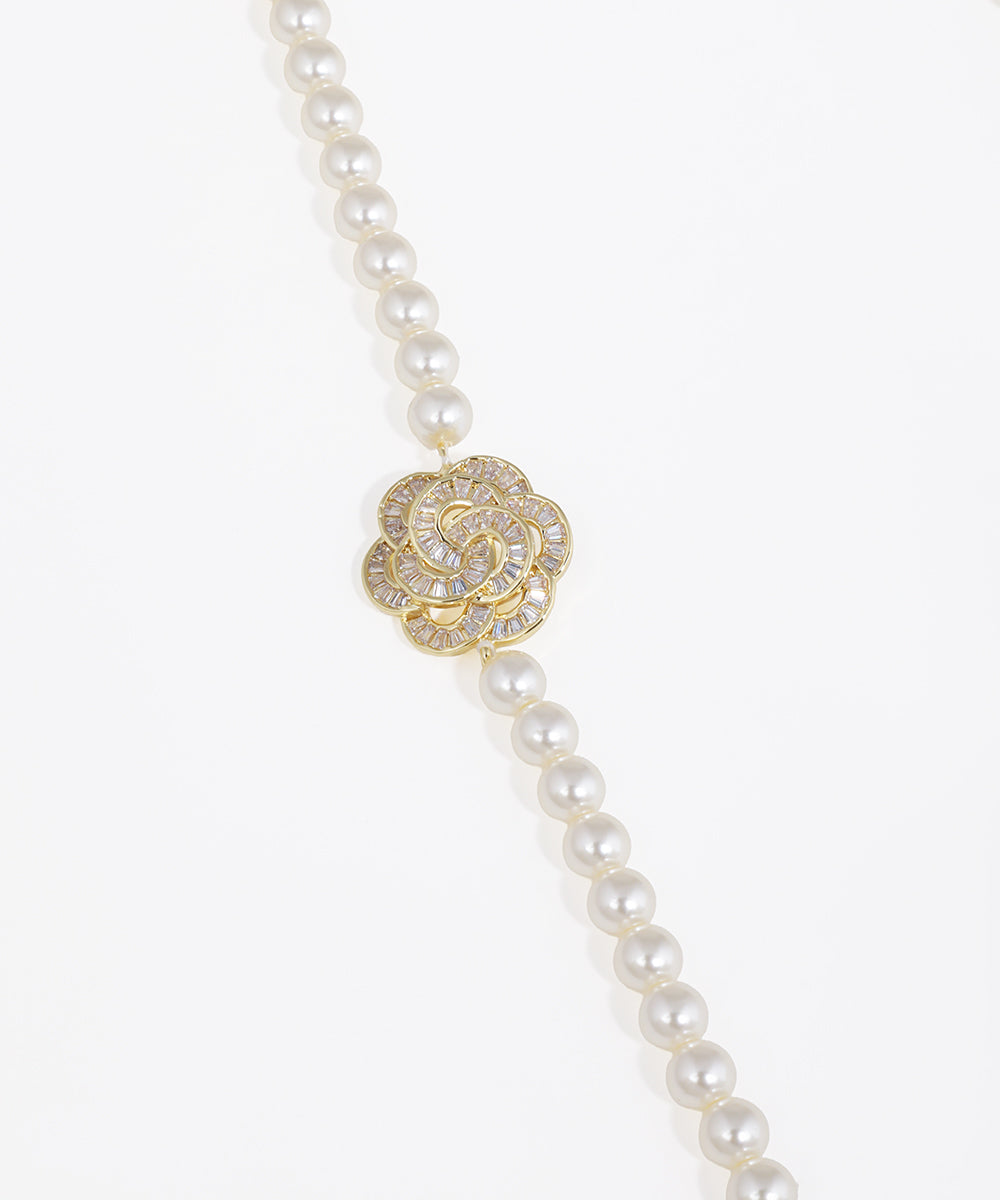 Pearl necklace with a gold and diamond clasp on a white background