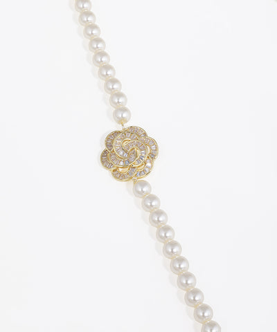 Pearl necklace with a gold and diamond clasp on a white background