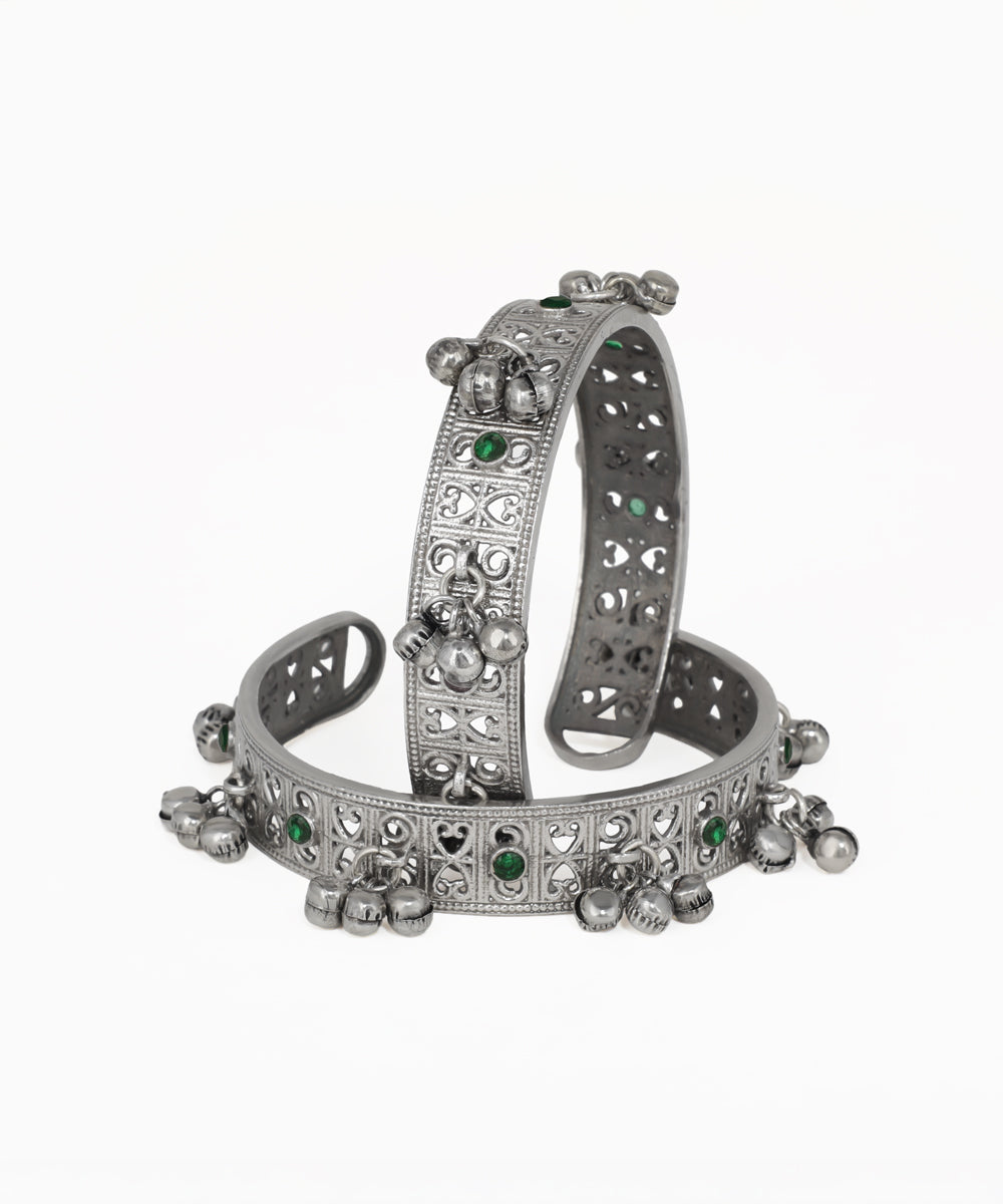 Silver bracelet with green gemstones on a white background