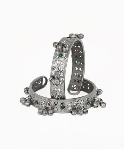 Silver bracelet with green gemstones on a white background
