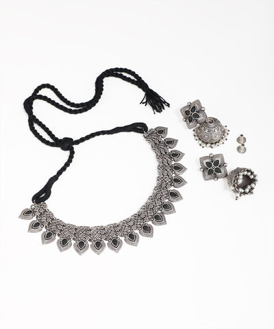 Silver necklace with black cord and matching earrings on a white background