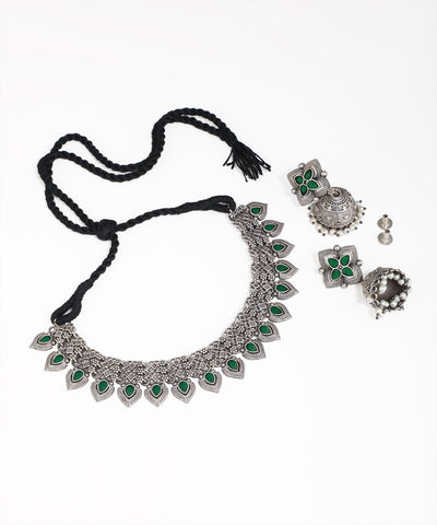 Silver necklace with green stones and matching earrings on a white background