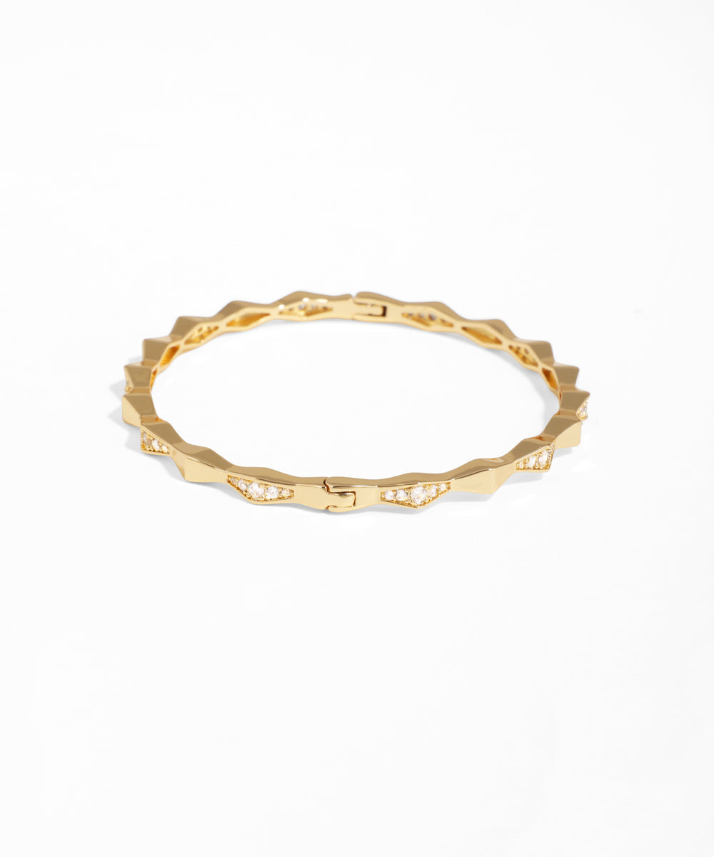 Gold ring with a textured band on a white background
