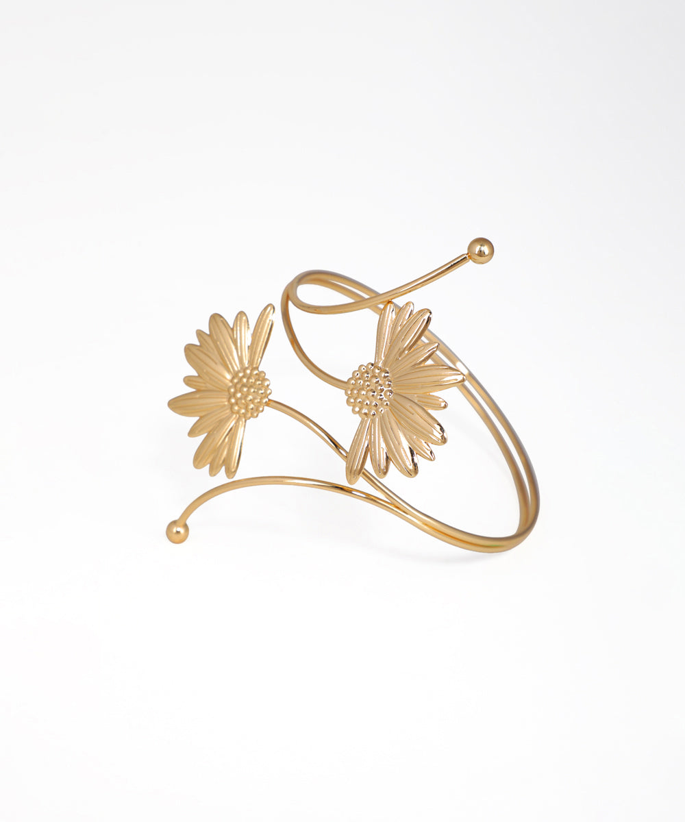 Gold bracelet with floral designs on a white background