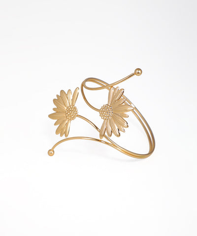 Gold bracelet with floral designs on a white background