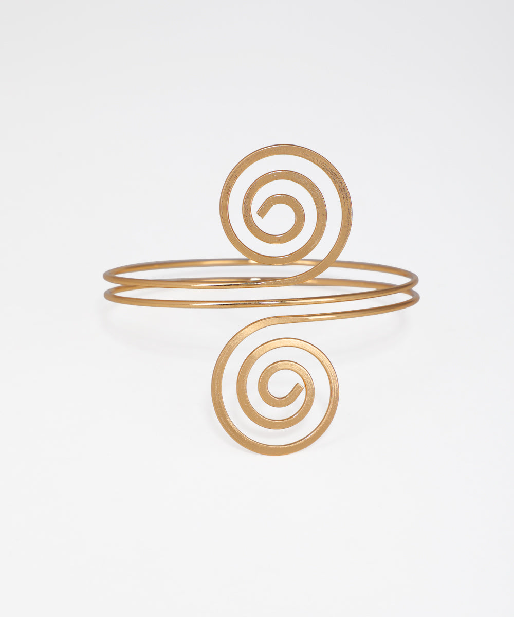 Gold spiral bracelet on a light gray background