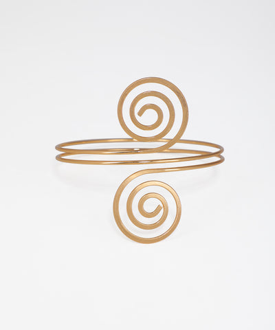 Gold spiral bracelet on a light gray background