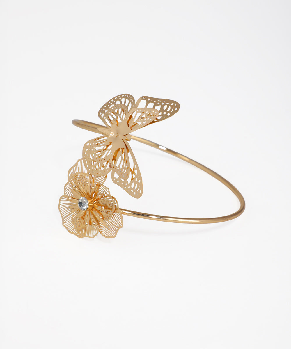 Gold butterfly and flower bracelet on a light gray background