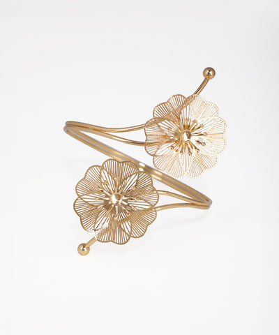 Gold floral bracelet on a light gray background