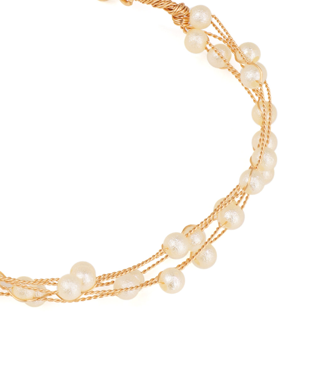 Multi-strand pearl necklace with gold accents on a white background