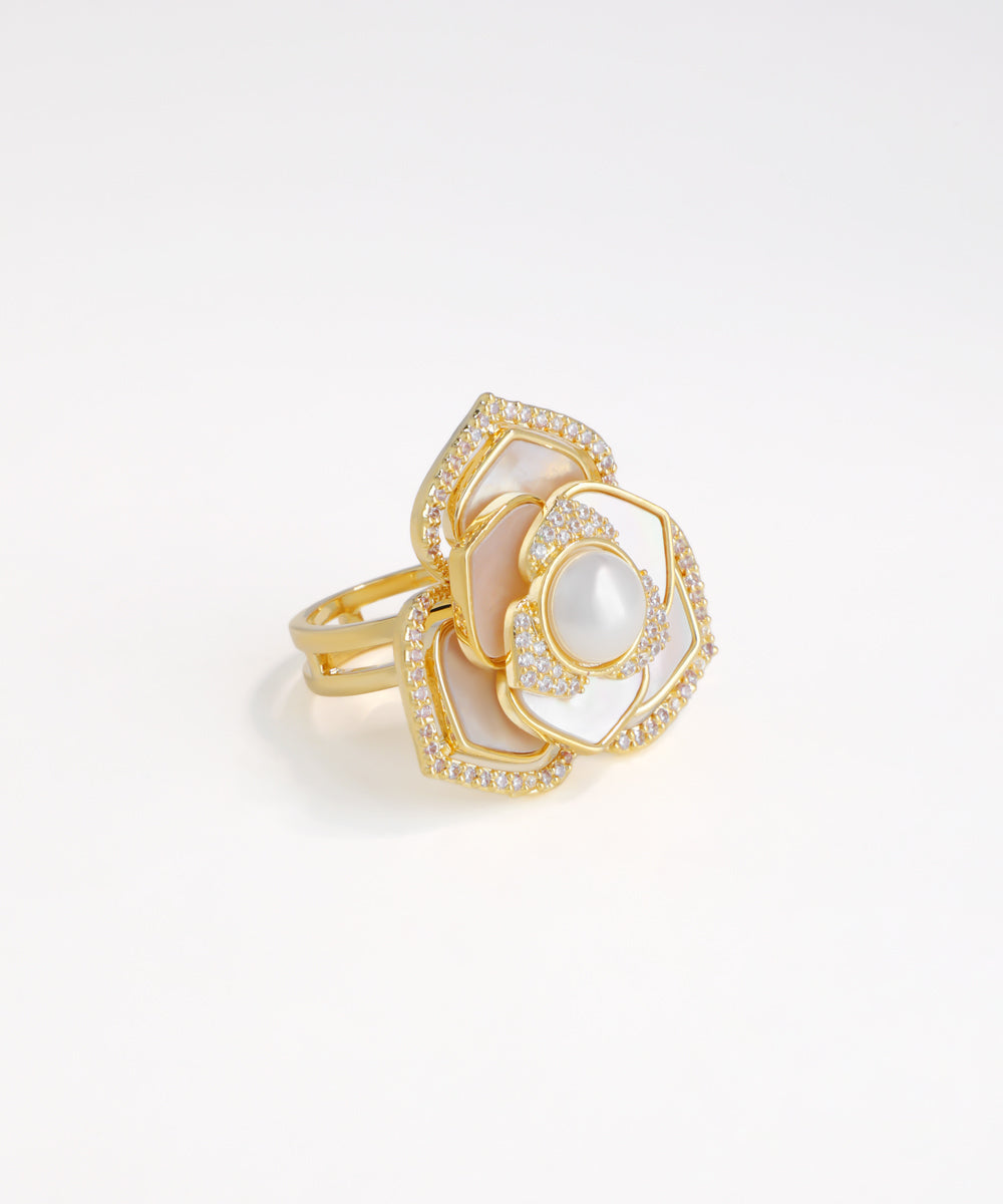 Gold ring with white stone on a light gray background