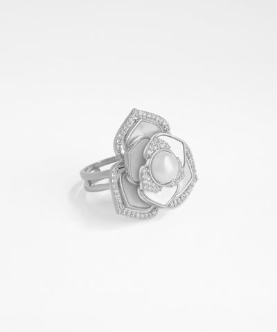 Silver ring with a central pearl and diamond accents on a white background
