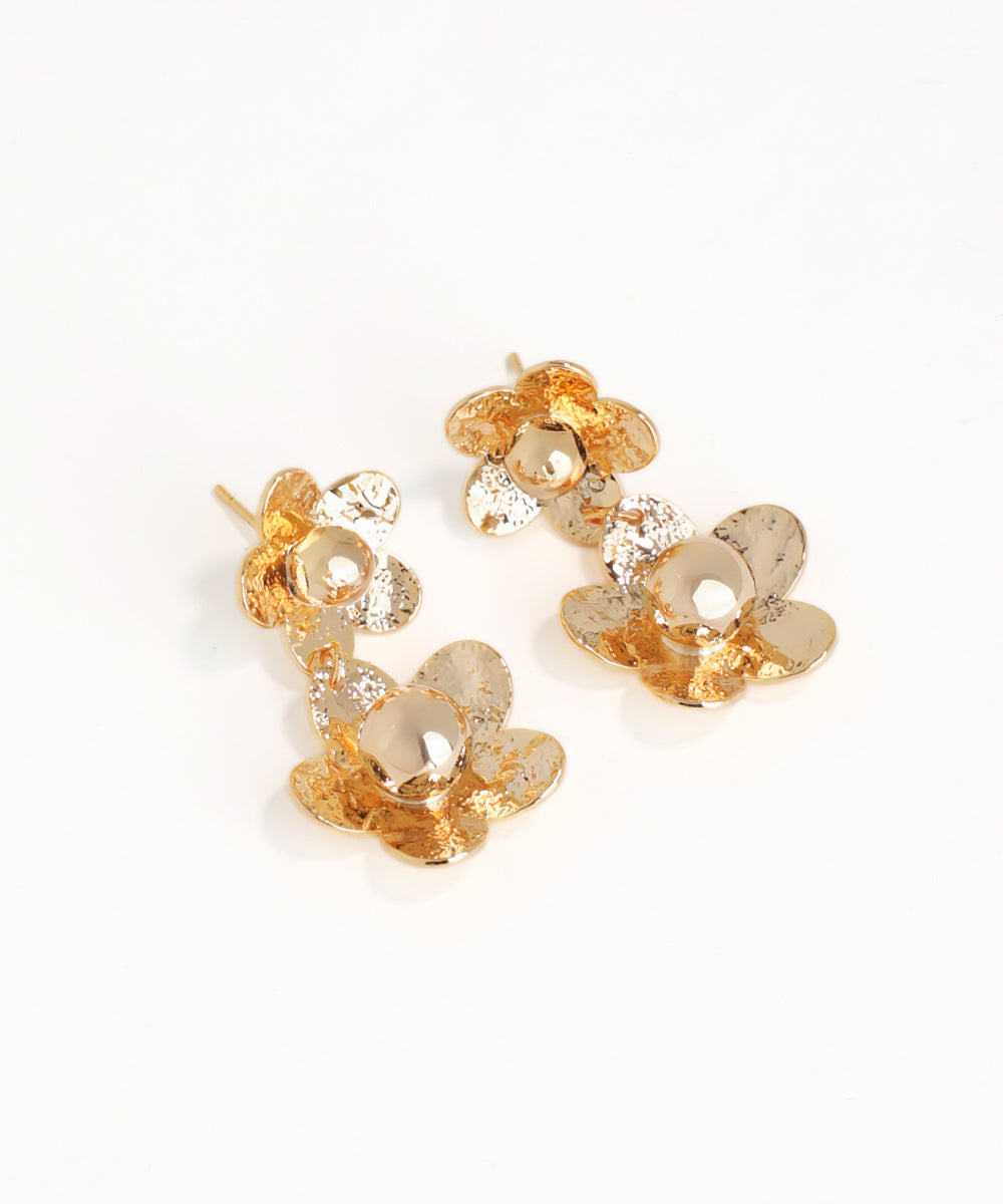 Gold floral earrings on a white background