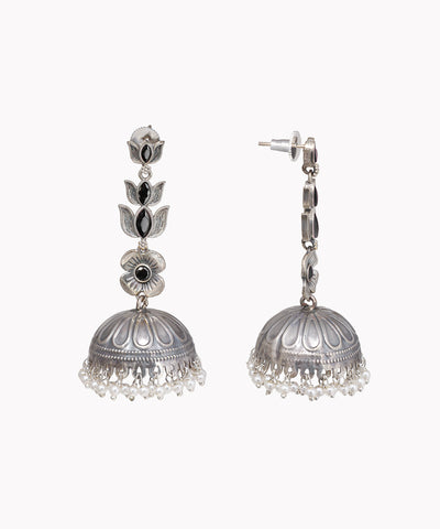 Pair of silver jhumka earrings with black stones on a white background