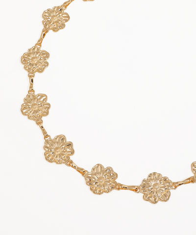 Gold floral necklace on a white background