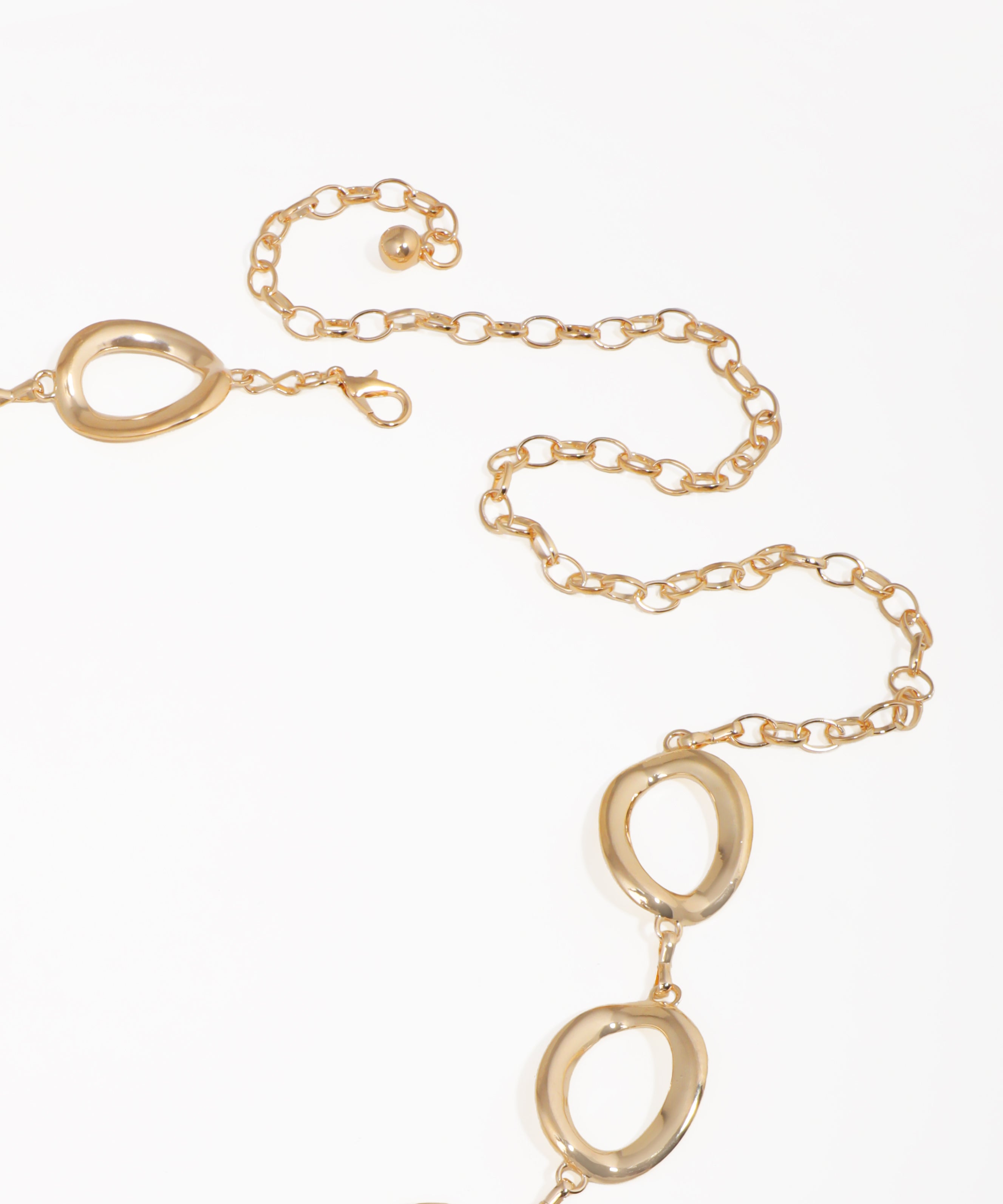 Gold necklace with interlocking oval pendants on a white background