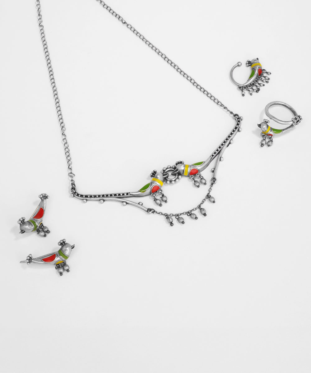 Silver jewelry set with colorful bird pendants on a white background