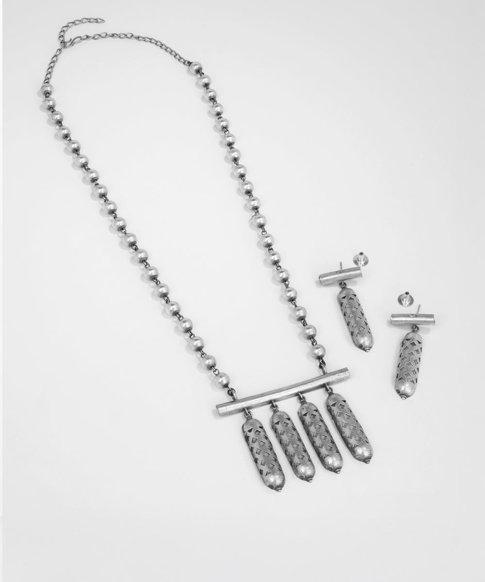 Silver necklace and earrings set on a light gray background