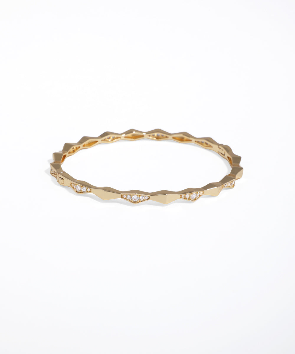 Gold ring with a textured band on a white background