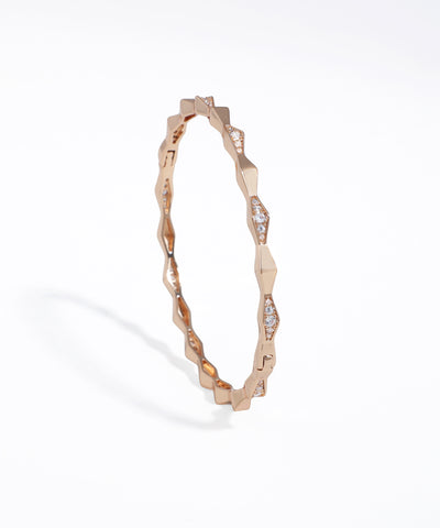 Rose gold bracelet with diamond accents on a white background