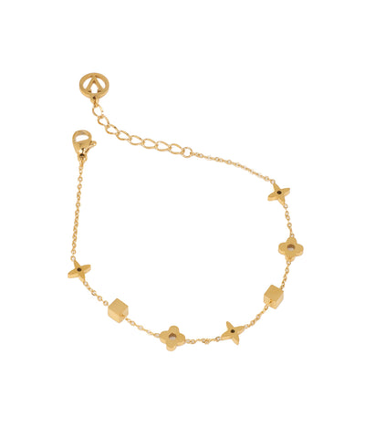 Gold-tone bracelet with alternating geometric cube and four-petal floral charms on a delicate chain.