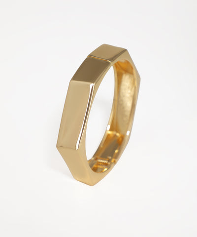 Gold ring with geometric design on a white background