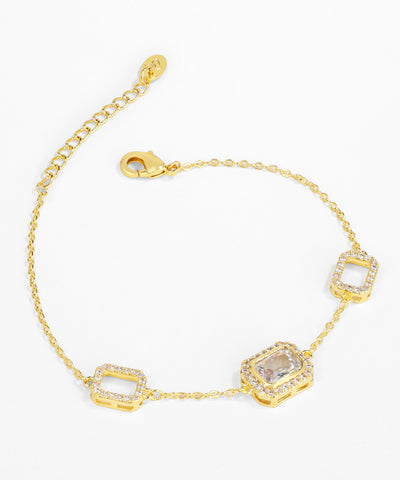 Gold bracelet with square-shaped gemstones on a white background