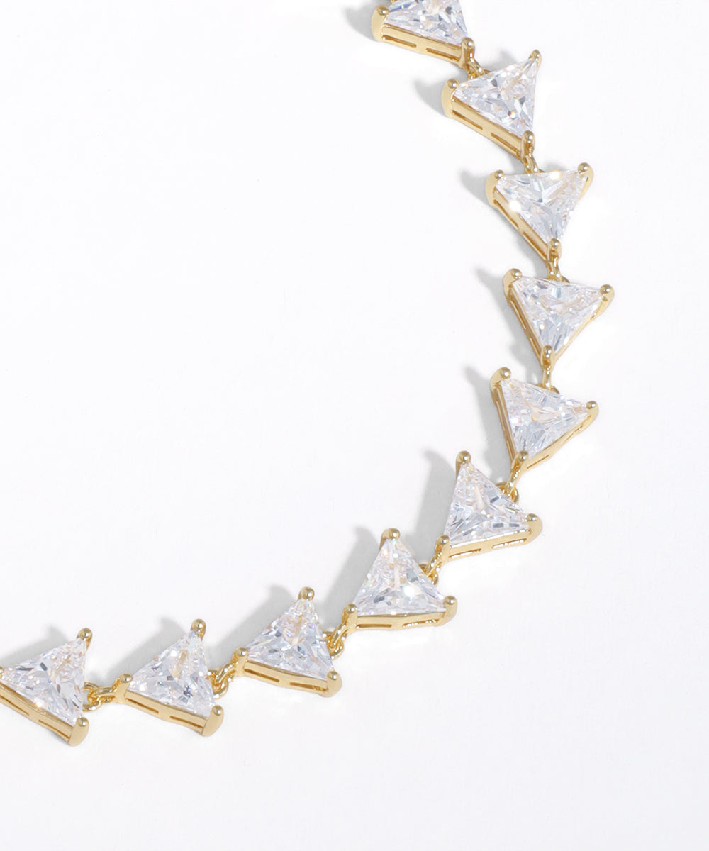Gold necklace with triangle-shaped clear stones on a white background