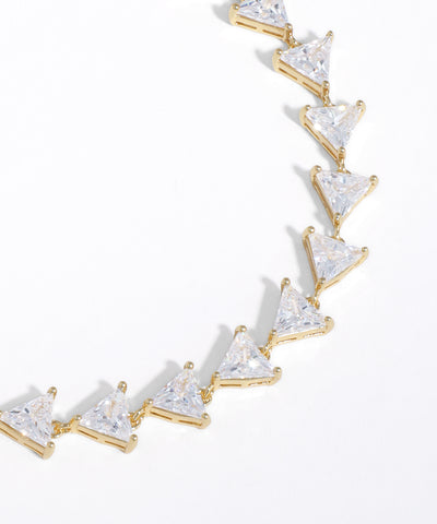 Gold necklace with triangle-shaped clear stones on a white background