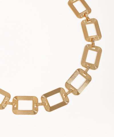 Gold chain necklace with rectangular links on a white background