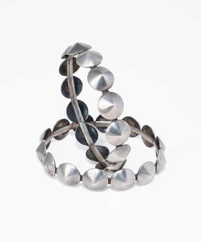 Oxidised silver-tone bangles with alternating flat discs and pointed stud details.