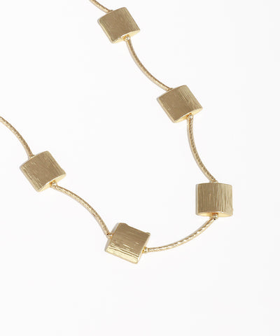 Gold necklace with square pendants on a white background