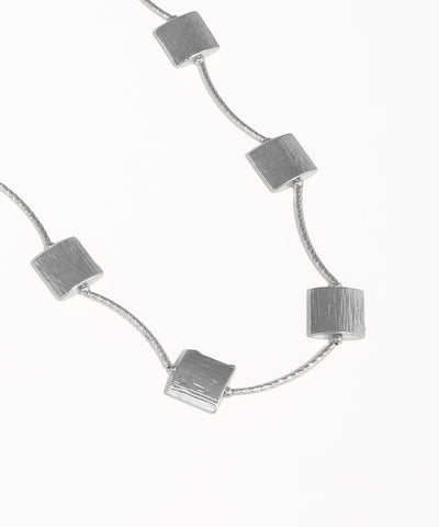 Silver necklace with square pendants on a white background