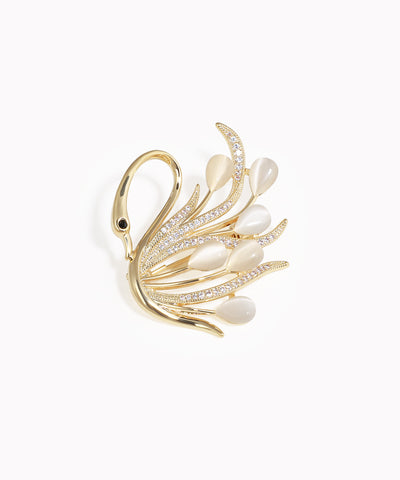 Gold-tone brooch with swan design, clear CZ stones, and white faux cat eye teardrops