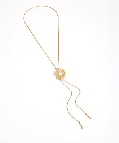 Gold-tone necklace with textured floral motif and faux pearl center, featuring adjustable lariat chains.