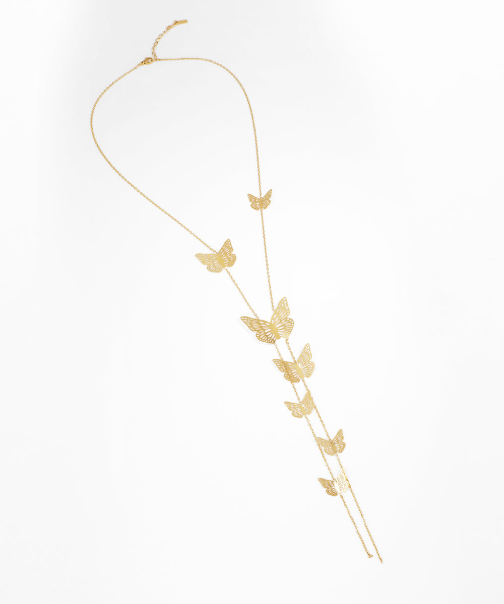 Gold butterfly necklace on a white background
