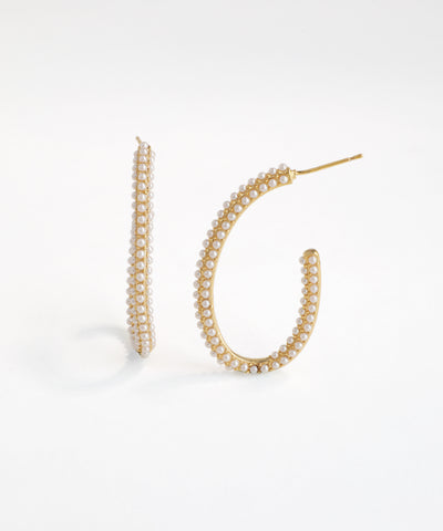Gold hoop earrings with pearl-like beads on a white background