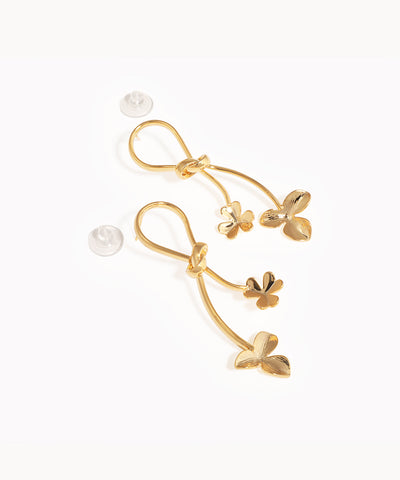 Gold-tone drop earrings with a knotted loop design and two delicate stems featuring stylized leaves.