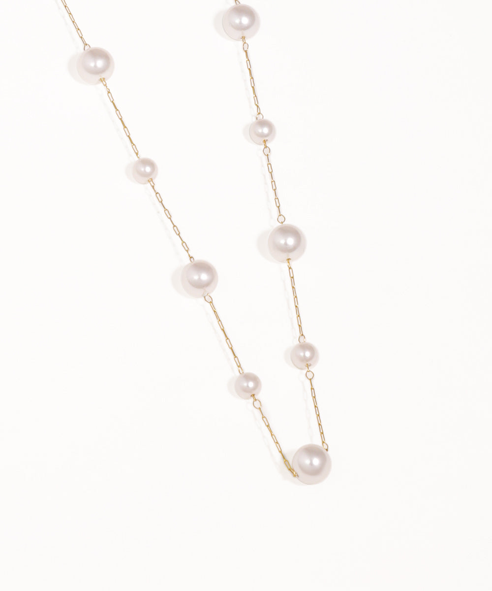 Pearl necklace with gold chain on a white background