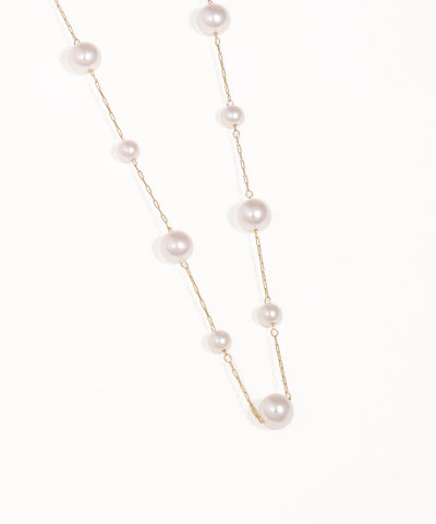 Pearl necklace with gold chain on a white background