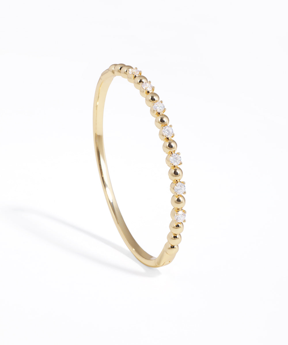 Gold-tone bracelet with alternating cubic zirconia stones and beads