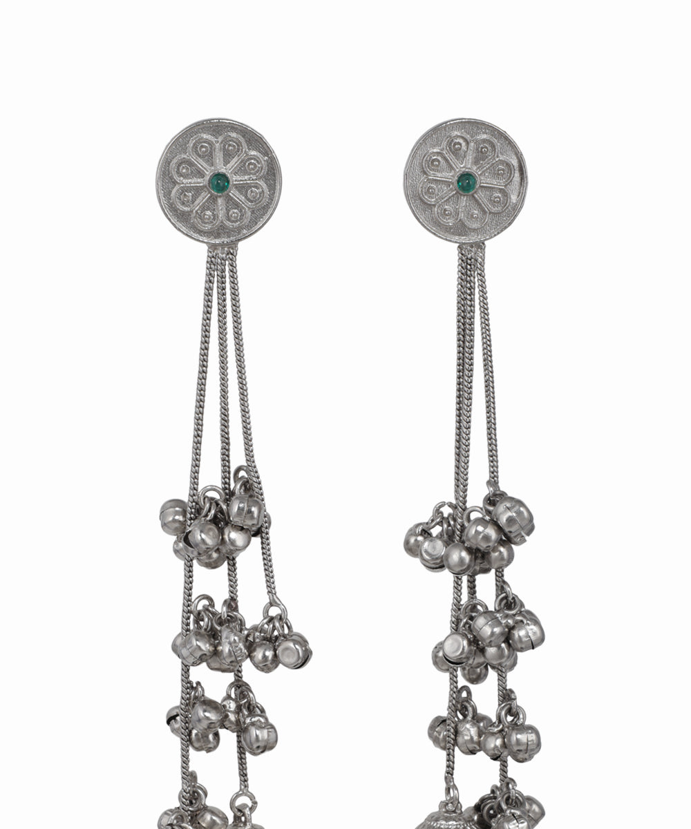 Pair of silver earrings with chain and bead details on a white background