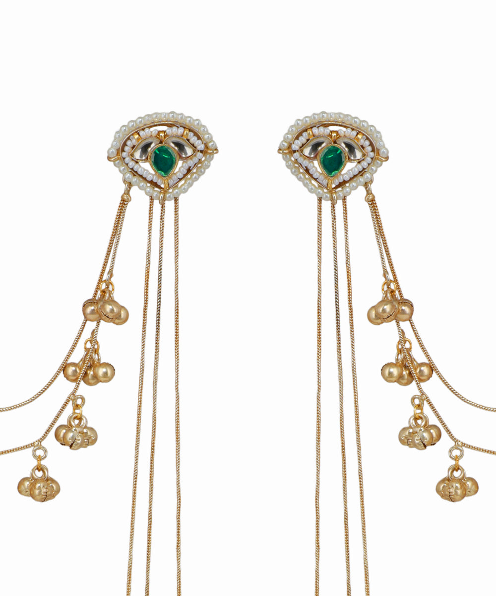 Gold earrings with green gemstones and dangling beads on a white background