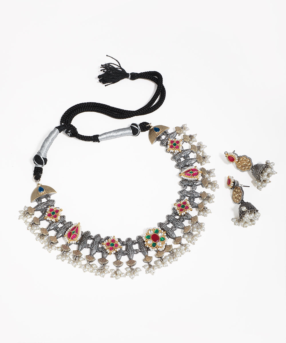 Oxidised silver-tone necklace set with floral motifs, red and green stones, and faux pearl drops