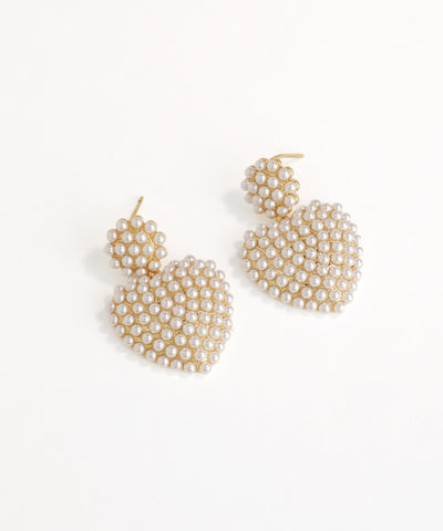 Pair of gold and pearl drop earrings on a white background