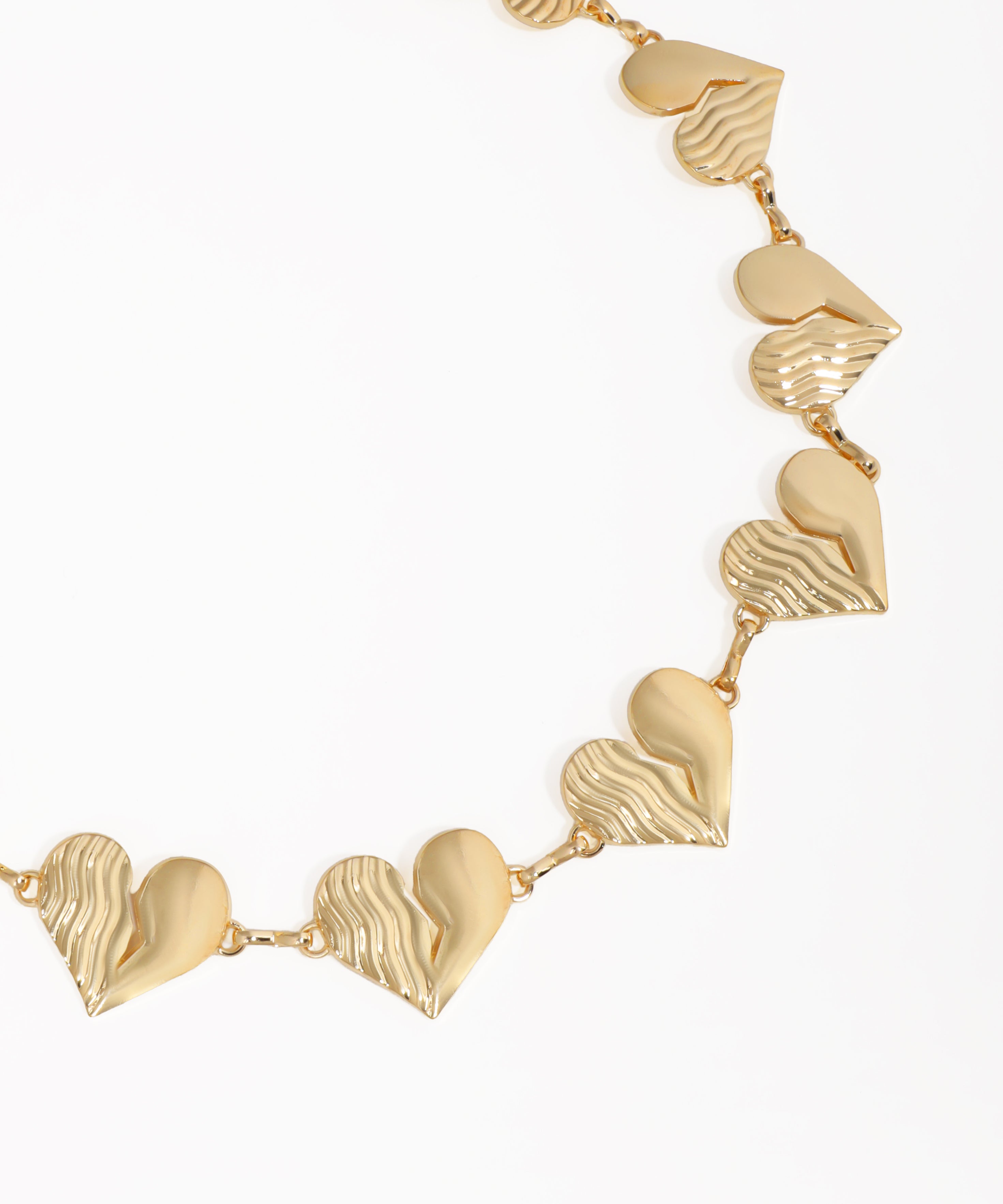 Gold necklace with heart-shaped pendants on a white background