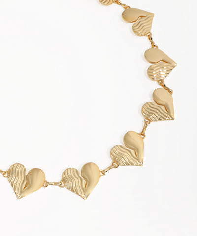 Gold necklace with heart-shaped pendants on a white background