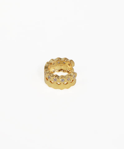 Gold ring with star-shaped stones on a white background