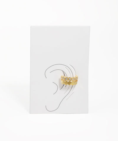 Gold earring displayed on a white card with an ear illustration