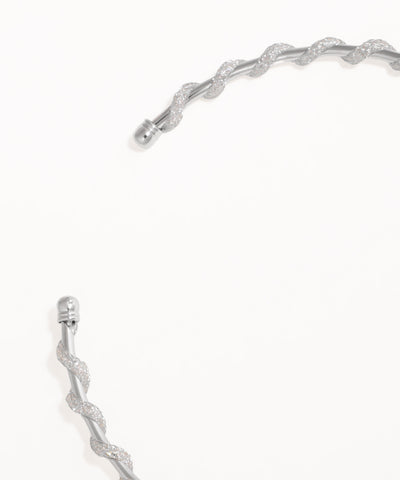 Silver bracelet with a textured design on a white background